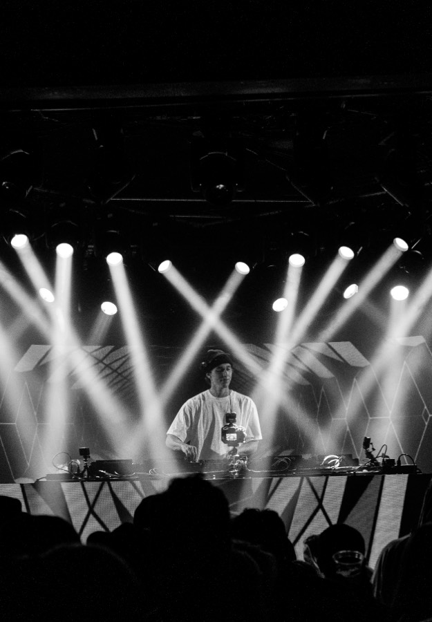 BBYFERG behind the decks under stage lights