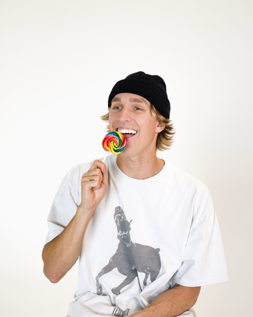 BBYFERG in a beanie with a rainbow lollipop